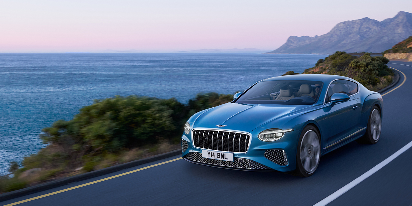 Bentley Yerevan New Bentley Continental GT Azure coupe in Light Windsor blue paint with 22 inch Azure wheels and chrome grill, driving dynamically by the sea